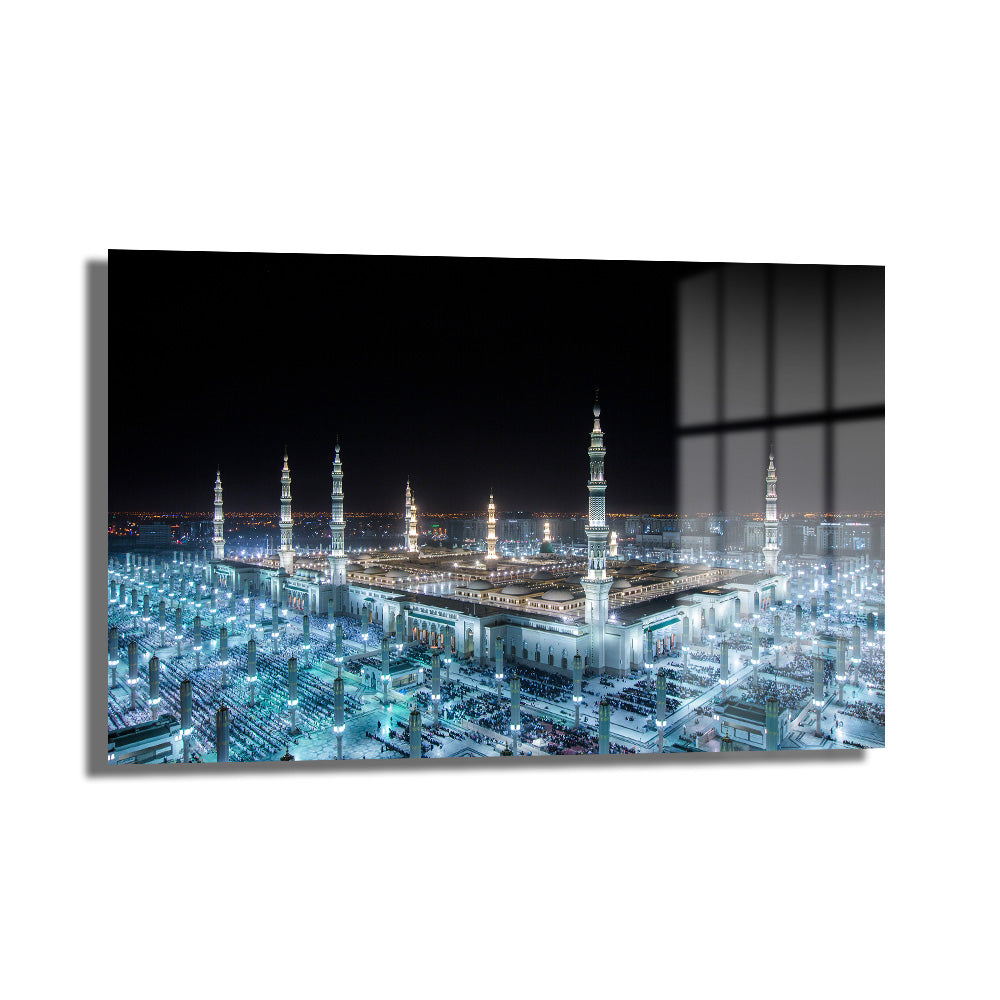Medine'nin Işıltısı: Mescid-i Nebevi Gece Manzarası Cam Tablo, Mescid-i Nebevi'nin minareleri ve parlayan avlusunu gösteren ruhani bir gece manzarası.