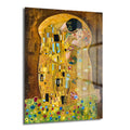 Gustav Klimt'in ikonik 'Öpücük' tablosunun cam üzerine basılmış hali. Altın rengi ve süslü desenlerle bezenmiş, birbirini kucaklayan bir çifti gösteren, alt kısmında renkli çiçeklerin olduğu romantik ve sanatsal bir görsel.