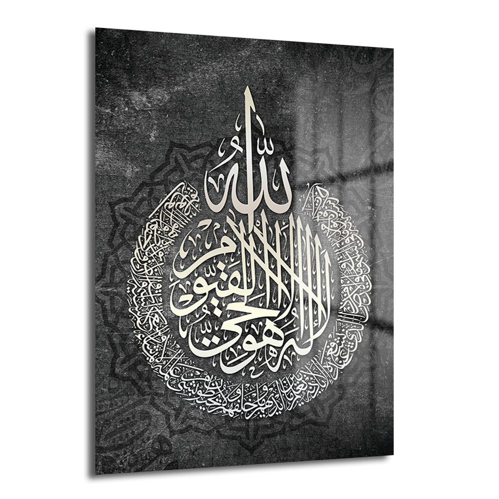 Koyu gri zeminde, beyaz ve bej tonlarında Ayatul Kürsi hat sanatıyla yazılmış İslami kaligrafi cam tablo. Ortasında Allah yazısı, etrafında dairesel olarak Ayatul Kürsi ayeti yer alıyor. Arka planda hafif desenli bir mozaik motif bulunuyor.