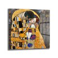 Gustav Klimt'in 'Öpücük' tablosunun altın, siyah ve renkli desenlerle bezenmiş, birbirine sarılmış bir çifti gösteren, sanatsal detaylara sahip bir cam tablo reprodüksiyonu.