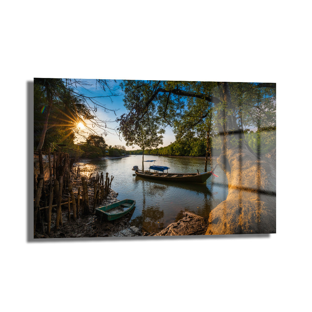 Altın Saatler: Nehirde Gün Batımı Manzaralı Temperli Cam Tablo, nehir üzerinde gün batımının altın rengi ışıkları, yeşil ağaçlar ve demirlemiş teknelerle huzurlu bir doğa manzarasını gösteren dekoratif temperli cam tablo.