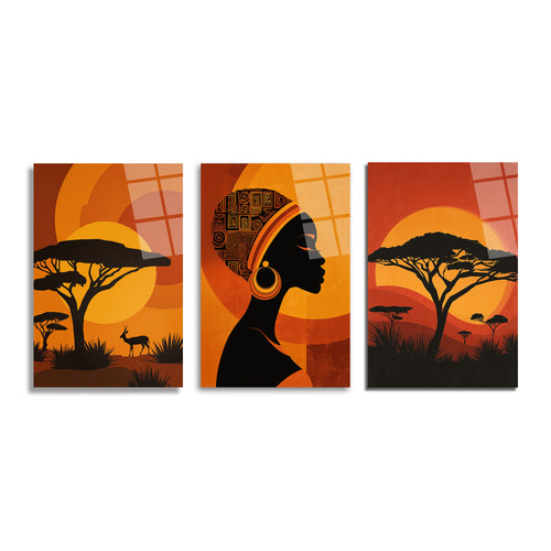 Afrika savanasında gün batımını, silüet halindeki akasya ağaçlarını, bir antilopu ve etnik desenli başörtüsü ile profilden bir Afrika kadını gösteren üçlü cam tablo seti.
