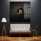 Koyu gri duvarda asılı, siyah zemin üzerine altın renkli parıltılı Bitcoin sembolü ve etrafında dönen soyut ızgara desenli modern cam tablo. Altında beyaz modern bir kanepe ve ahşap aksesuarlar bulunuyor.