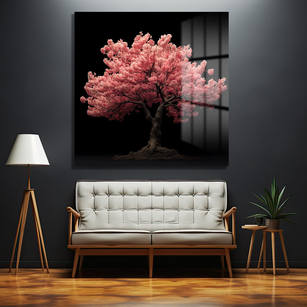 Koyu gri bir duvarda asılı, parlak pembe kiraz çiçekleri açmış bir sakura ağacının resmedildiği büyük, yansıtıcı bir cam tablo. Tablonun altında beyaz, düğmeli bir kanepe, solunda ahşap ayaklı bir lambader, sağında ise küçük bir sehpa üzerinde yeşil bir bitki bulunmaktadır. Zemin ahşap parke olup, genel atmosfer modern ve huzurludur.