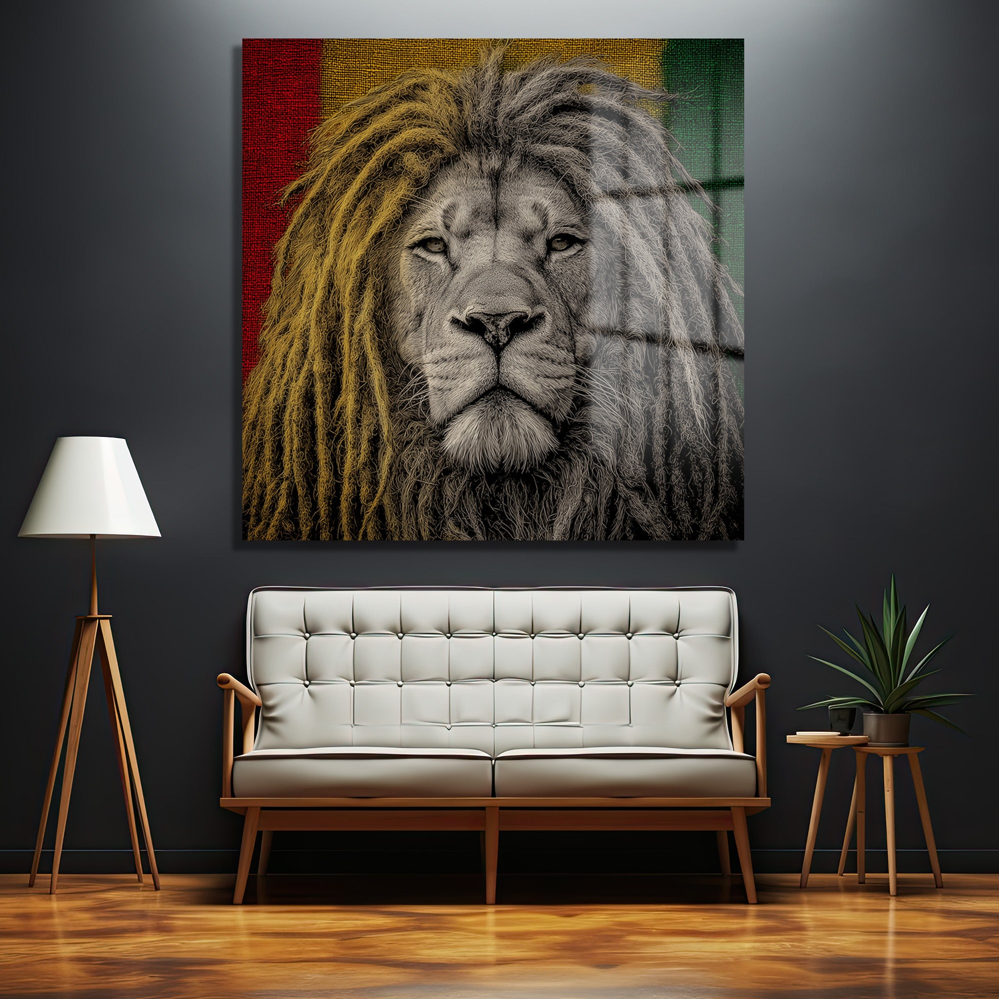 Koyu gri duvarda asılı, rastafari renklerinde (kırmızı, sarı, yeşil) arka plana sahip, dreadlock'lu, güçlü ve asil bir aslanın yakın çekim portresi olan cam tablo. Altında modern beyaz bir koltuk ve ahşap detaylar bulunmaktadır.
