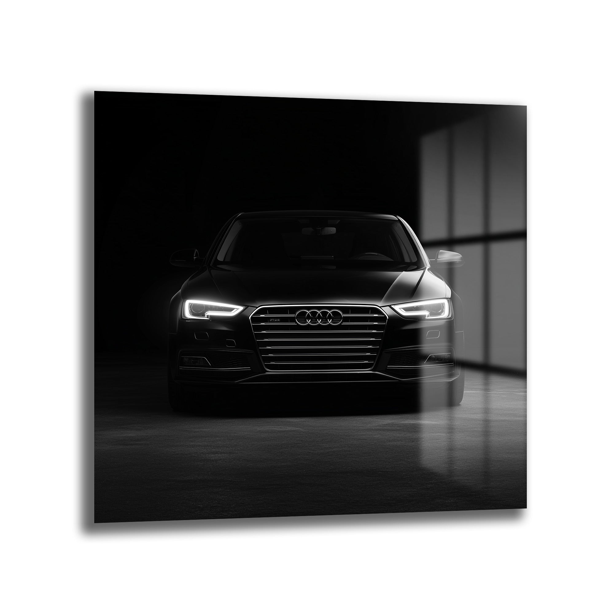Karanlık bir ortamda, parlak farları açık, önden çekilmiş siyah renkli modern Audi otomobilin cam tablo görünümü.