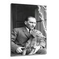 Siyah beyaz bir fotoğraf karesinde, takım elbiseli Mustafa Kemal Atatürk'ün kucağında oturan Foks isimli köpeğiyle birlikte dışarıya doğru baktığı, düşünceli bir anı gösteren cam tablo.