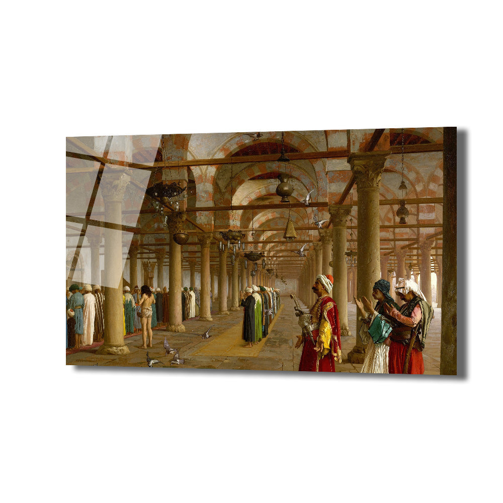 Kemerli ve sütunlu bir cami veya medrese koridorunda, geleneksel kıyafetler içinde namaz kılan ve sohbet eden insanları gösteren oryantalist bir tablo. Yerde güvercinler, tavanda asılı lambalar ve uzaklara uzanan bir perspektif bulunmaktadır. Resimde kırmızı, yeşil, kahverengi ve bej tonları hakimdir.