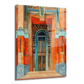 Art Deco tarzında, turuncu, mavi ve altın renklerin hakim olduğu, süslü bir bina girişini gösteren cam tablo. Geometrik desenler ve detaylı kapı motifleri ön planda.