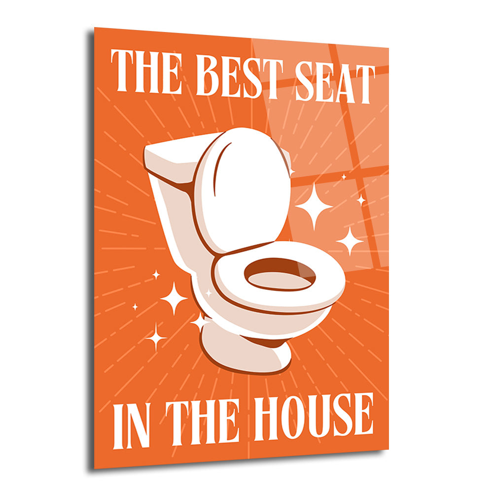 Turuncu arka planda, beyaz bir klozetin parıltılarla vurgulandığı ve "THE BEST SEAT IN THE HOUSE" yazısının yer aldığı, mizahi temalı bir cam tablo.