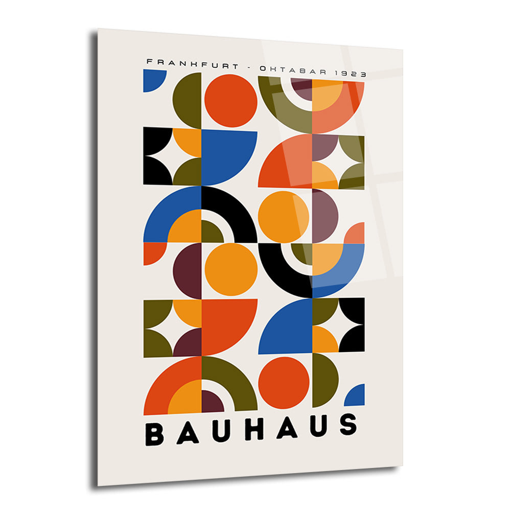 Açık bej zemin üzerinde turuncu, mavi, siyah, bordo ve zeytin yeşili renklerde dairesel ve yarım dairesel geometrik desenlerin tekrarlandığı, 'FRANKFURT - OHTABAR 1923' ve 'BAUHAUS' yazılarının bulunduğu modern sanatsal cam tablo.