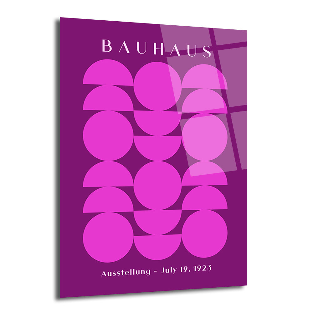 Koyu mor arka plan üzerinde, parlak pembe daire ve yarım dairelerden oluşan geometrik desenli, Bauhaus stilinde bir cam tablo. Üstte 'BAUHAUS', altta 'Ausstellung - July 19, 1923' yazıları beyaz renkte.