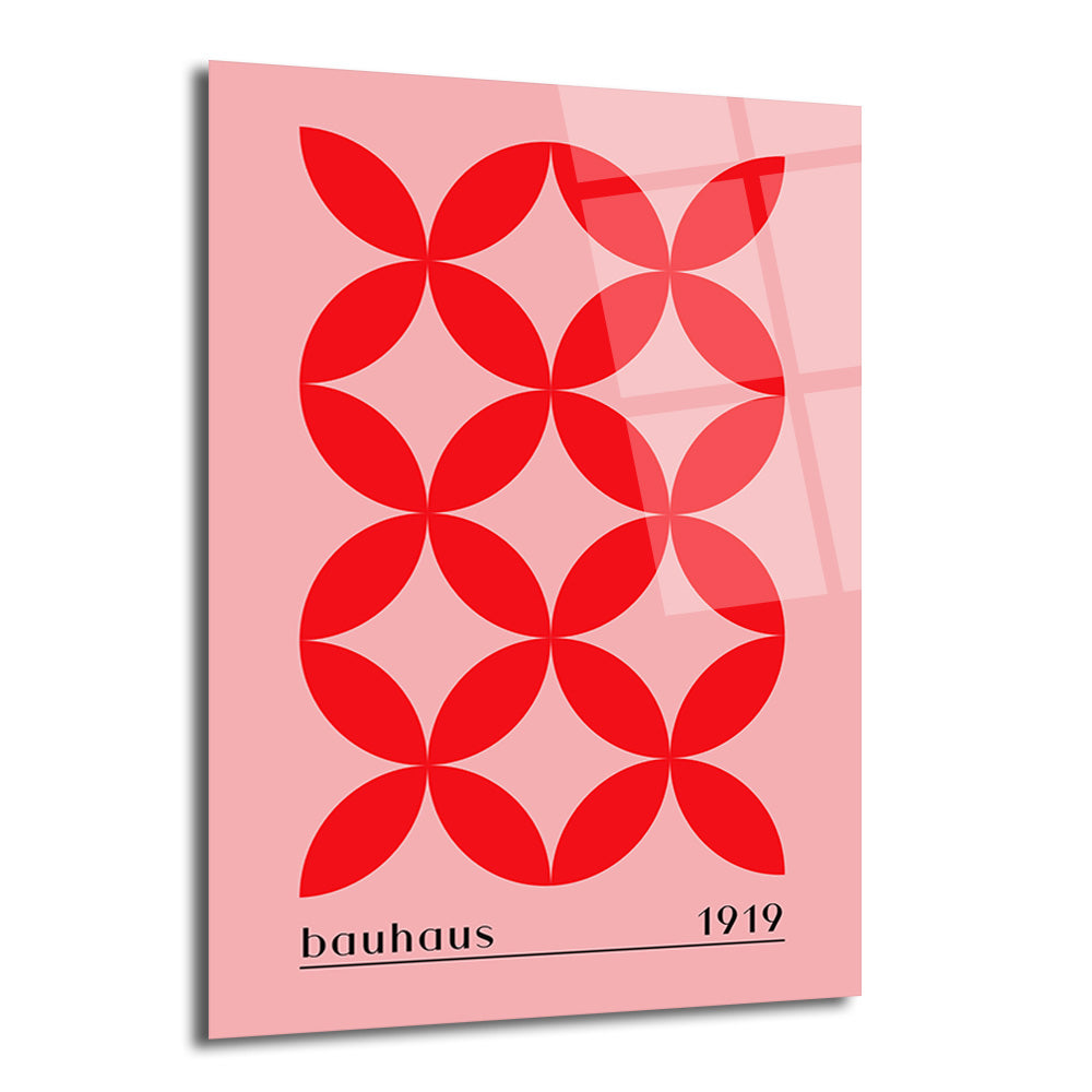 Pembe zeminde kırmızı renkte tekrarlayan geometrik dört yapraklı desenlere sahip, altında 'bauhaus' ve '1919' yazan modern cam tablo.