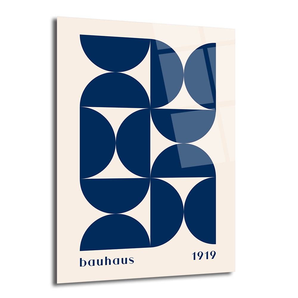Krem rengi zeminde koyu lacivert yarım daire ve çeyrek dairelerin oluşturduğu geometrik, soyut Bauhaus tarzı bir desenin yer aldığı parlak yüzeyli cam tablo. Tablonun altında 'bauhaus 1919' yazısı bulunmaktadır.