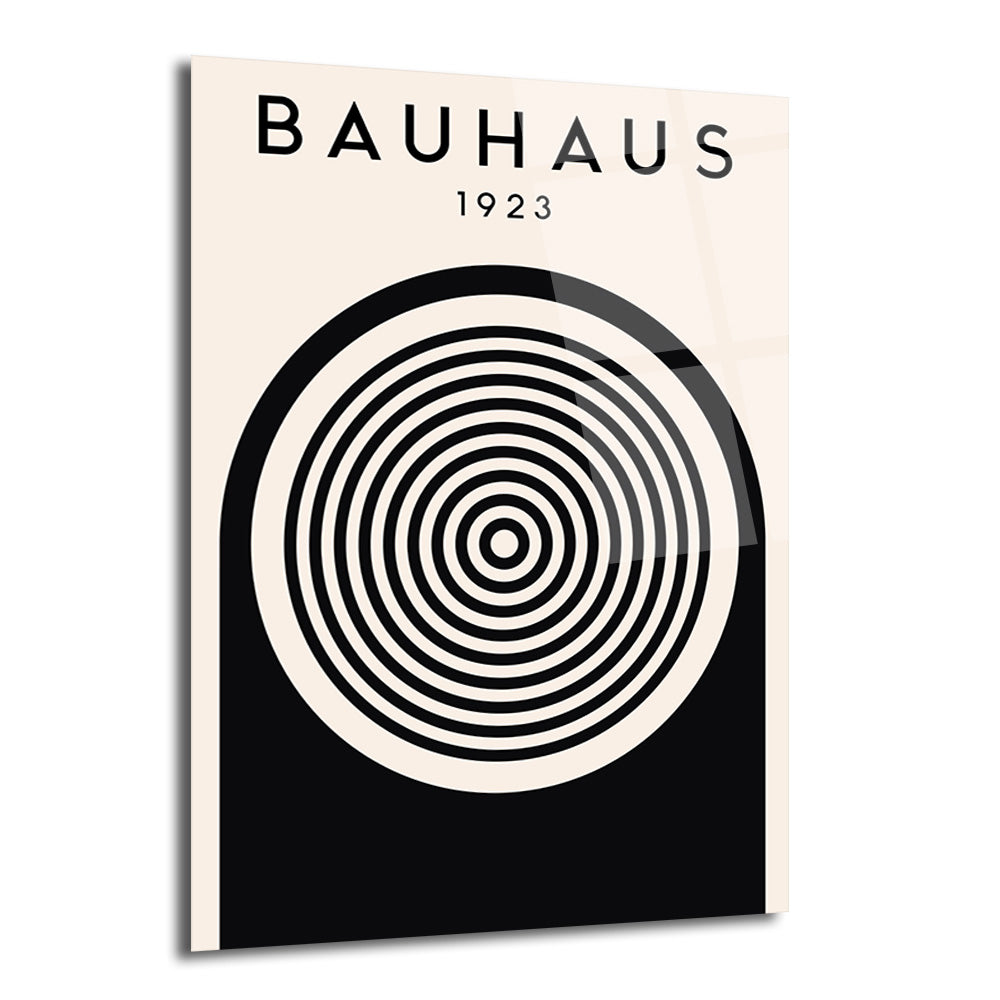 Bauhaus 1923 yazılı, bej zemin üzerinde siyah konsantrik çemberler ve alt kısımda siyah bir yarım daire bulunan modern minimalist cam tablo.