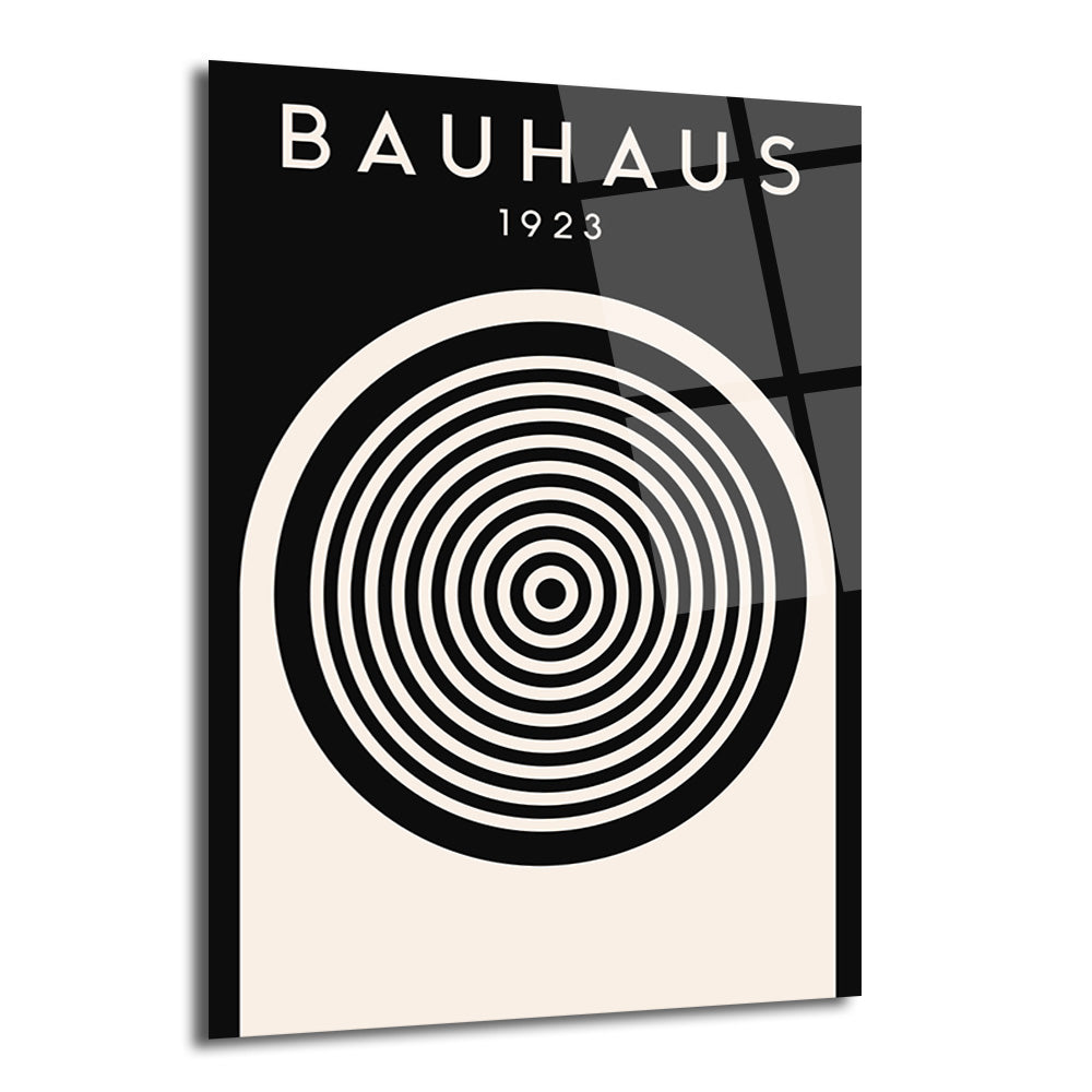 Siyah ve krem rengi zemin üzerinde 'BAUHAUS 1923' yazısı ve ortasında siyah beyaz konsantrik dairelerden oluşan minimalist bir tasarıma sahip parlak cam tablo.
