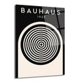 Siyah ve krem rengi zemin üzerinde 'BAUHAUS 1923' yazısı ve ortasında siyah beyaz konsantrik dairelerden oluşan minimalist bir tasarıma sahip parlak cam tablo.