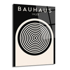 Siyah ve krem rengi zemin üzerinde 'BAUHAUS 1923' yazısı ve ortasında siyah beyaz konsantrik dairelerden oluşan minimalist bir tasarıma sahip parlak cam tablo.