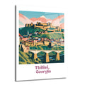 Tiflis, Gürcistan şehrinin tepelere yayılmış binalarını, tarihi kalesini, nehri ve köprüsünü gösteren modern illüstrasyon tarzında bir cam tablo. Arka planda pembe bulutlar ve açık mavi gökyüzü bulunmaktadır.