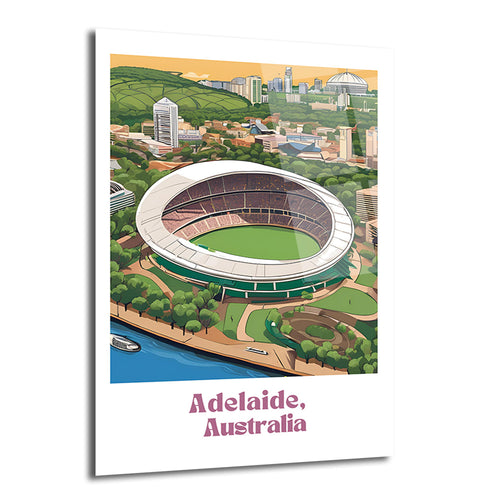 Adelaide, Avustralya'daki Adelaide Oval Stadyumu'nun kuşbakışı çizimi. Yeşil saha, beyaz çatı, çevresindeki ağaçlık alanlar, nehir ve şehir silüeti canlı renklerle tasvir edilmiştir. Resmin altında "Adelaide, Australia" yazısı yer almaktadır.