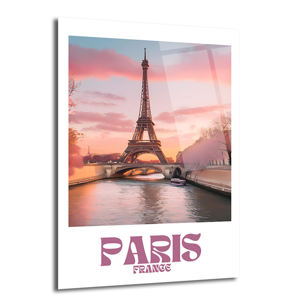 Eyfel Kulesi'nin Seine Nehri üzerinde gün batımında çekilmiş, pembe ve turuncu gökyüzüyle aydınlanan romantik bir fotoğrafını gösteren, altında 'PARIS FRANCE' yazısı bulunan parlak bir cam tablo.