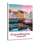 Kopenhag'ın Nyhavn bölgesindeki pastel tonlarda gökyüzü altında sıralanmış, suya yansıyan canlı renkli tarihi binalar ve kanalda yüzen pembe bir tekne.