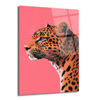 Canlı pembe arka plan önünde, profilden bakışla resmedilmiş, turuncu ve siyah benekli bir leopar başı ve boynunun yer aldığı modern cam tablo. Leoparın gözleri kehribar renginde, yüzünde sakin ve asil bir ifade var.