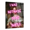 Klasik bir portre üzerine neon pembe harflerle "I WAS NOT MADE TO BE SUBTLE" yazılı, zarif bir kadının resmedildiği modern cam tablo.