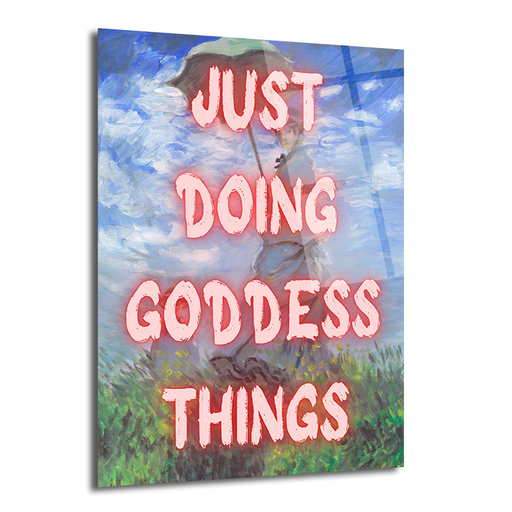 Monet tarzı bir resmin üzerine pembe, parlayan harflerle "JUST DOING GODDESS THINGS" yazısının eklendiği, elinde şemsiye tutan bir kadını ve arkasında mavi gökyüzü ile yeşil çimenleri gösteren modern cam tablo.