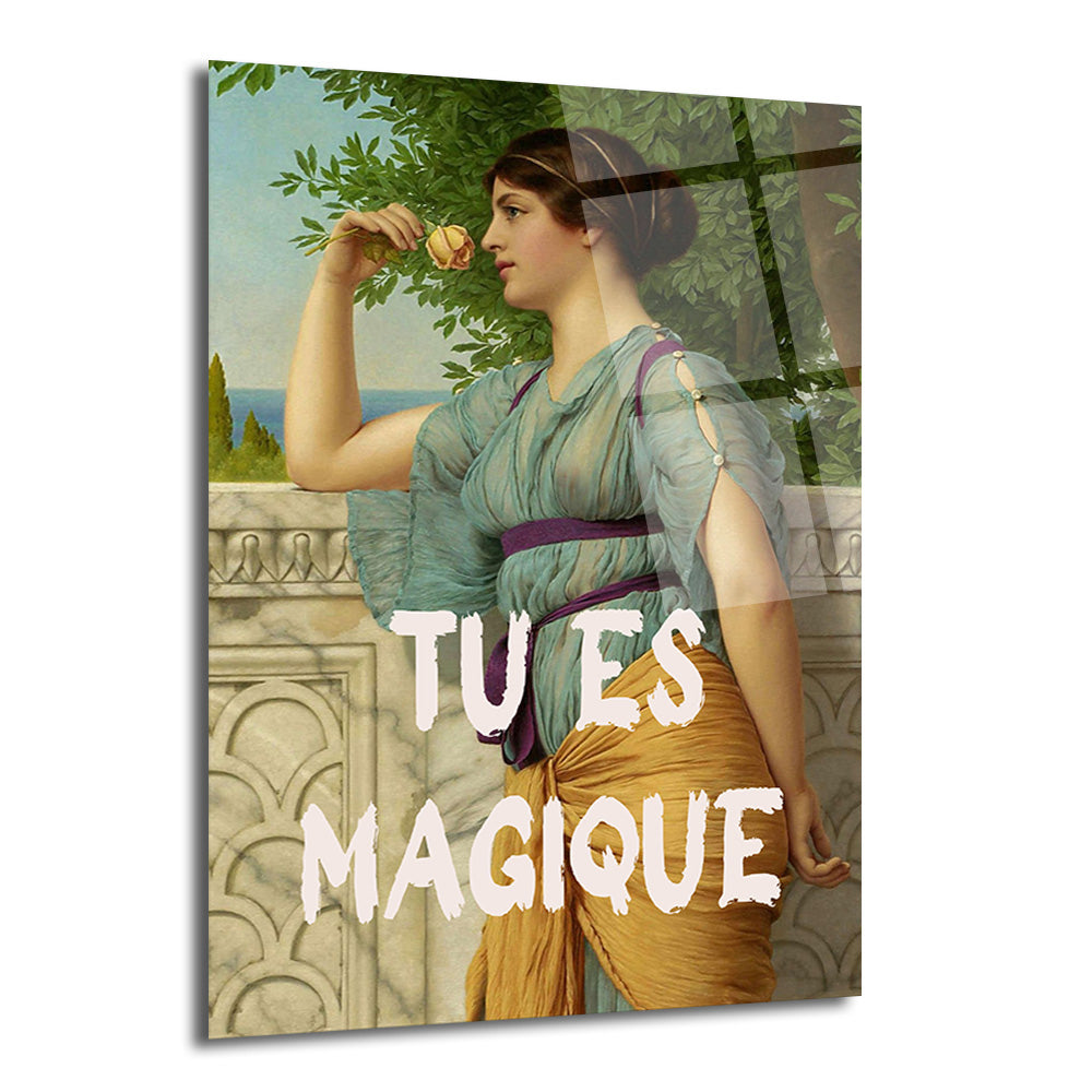 "Tu Es Magique" yazılı, turkuaz ve altın sarısı elbiseli, elinde pembe gül koklayan antik dönemden ilham alan bir kadın figürünün yer aldığı parlak cam tablo. Arka planda deniz manzarası ve yeşil ağaçlar görülüyor.