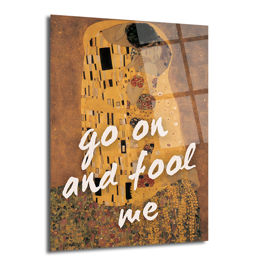 Gustav Klimt'in "Öpücük" eserinin altın ve kahve tonlarındaki yorumu üzerine beyaz el yazısıyla "go on and fool me" metni eklenmiş, yansımalı modern cam tablo.