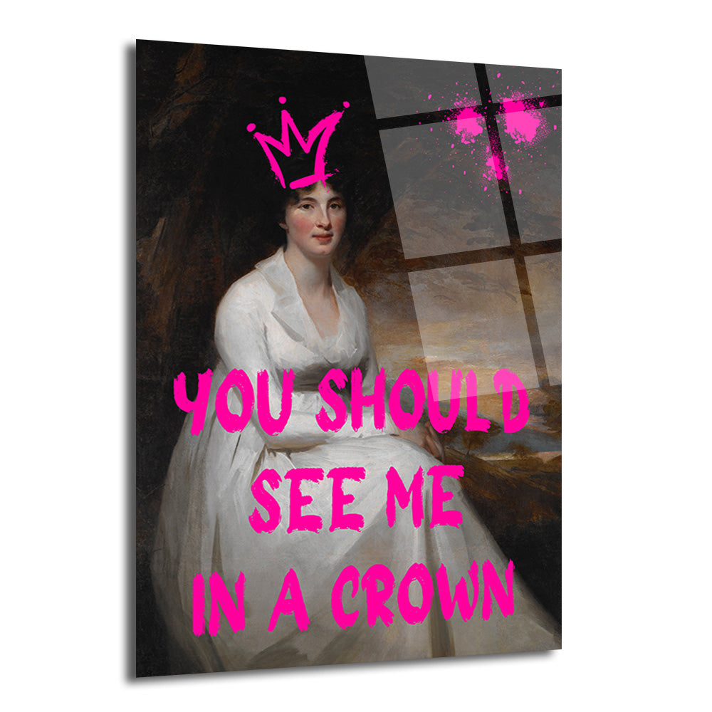 Koyu arka planda, beyaz elbiseli bir kadının klasik portresi üzerinde neon pembe renkte 'YOU SHOULD SEE ME IN A CROWN' yazısı ve taç grafiği bulunan modern cam tablo. Sanatsal boya sıçramaları da mevcut.