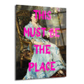 Mavi elbiseli bir kadının klasik portre tablosu üzerine parlak pembe renkte 'THIS MUST BE THE PLACE' yazılı modern cam tablo.