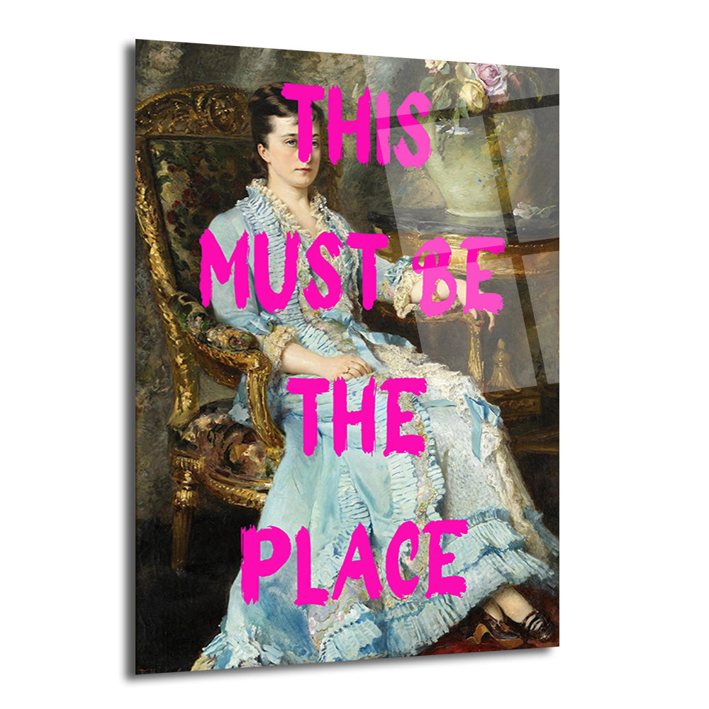 Mavi elbiseli bir kadının klasik portre tablosu üzerine parlak pembe renkte 'THIS MUST BE THE PLACE' yazılı modern cam tablo.