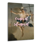 Klasik bir tablonun üzerine pembe "cupid stupid" yazısı eklenmiş, ok tutan kanatlı bir figürü betimleyen, modern ve ironik tasarımlı cam tablo.