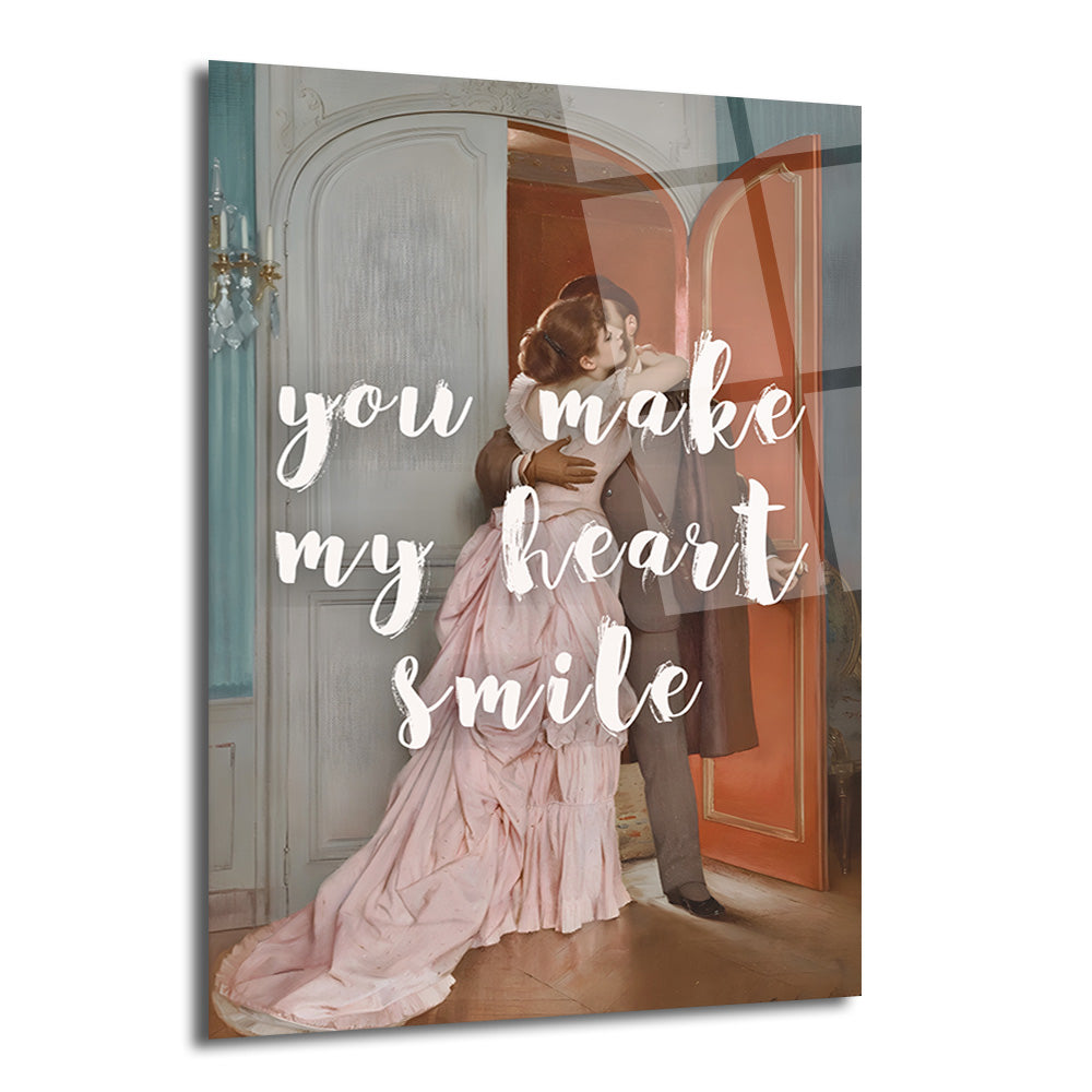 Pembe elbiseli bir kadının ve takım elbiseli bir erkeğin kapı eşiğinde sarıldığı, üzerinde 'You Make My Heart Smile' yazısı bulunan romantik bir cam tablo.