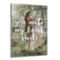 Yeşil ve beyaz çiçekli bir bahçede dans eden klasik giyimli romantik bir çiftin resmedildiği, üzerinde 'You Make My Heart Smile' yazılı Glazella cam tablo.