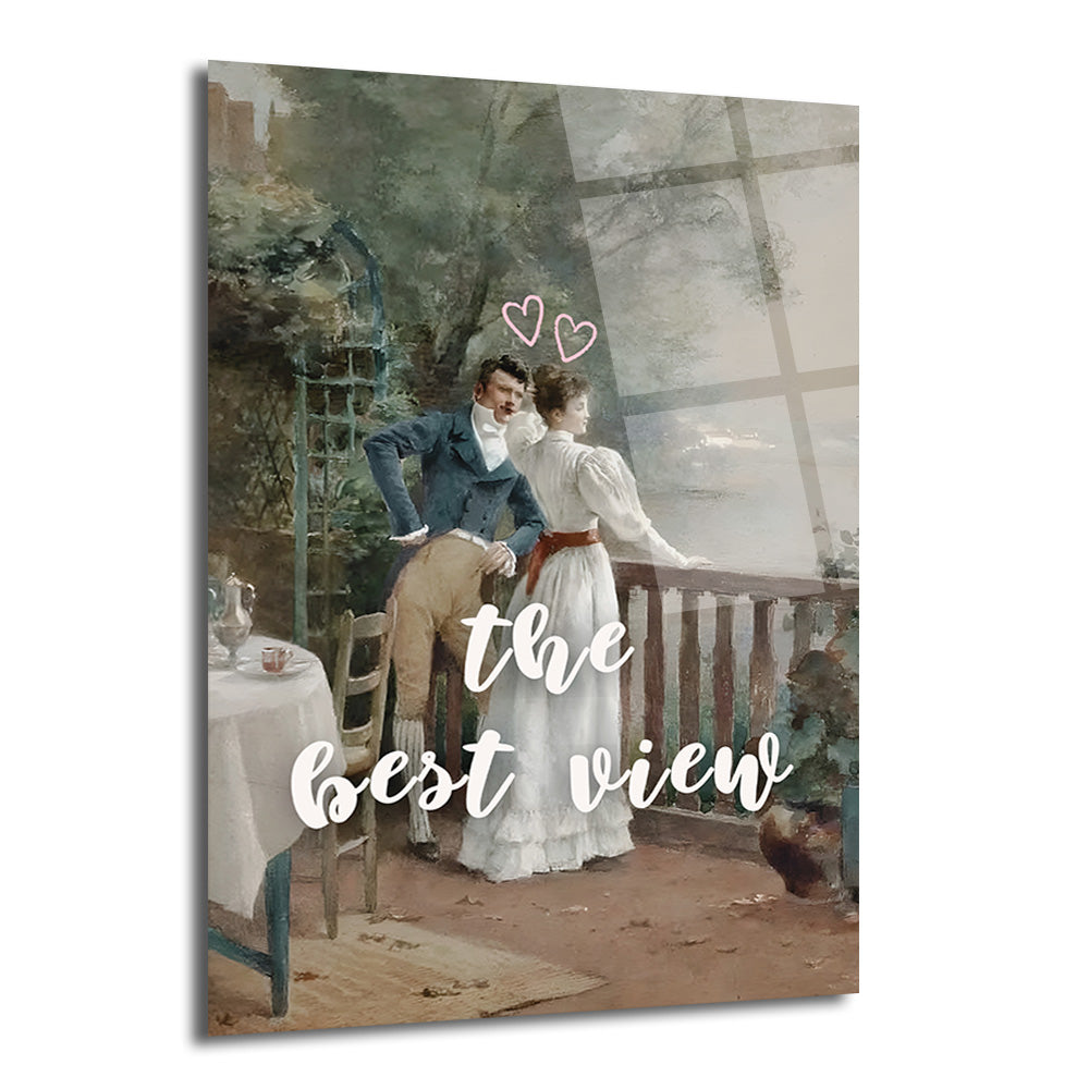 Balkonda duran, dışarıya bakan ve üzerinde 'the best view' yazısı ile iki kalp simgesi bulunan romantik bir çiftin resmedildiği cam tablo.
