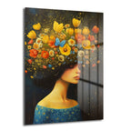 Rüya Bahçesi: Çiçeklerin Dansı Temalı Modern Cam Tablo, saçları canlı sarı, turuncu ve mavi çiçeklerle süslü, zarif bir kelebeğin eşlik ettiği bir kadın portresini karanlık arka plan ve altın ışıltılarla gösteriyor.
