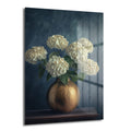 Elegansın Dokunuşu: Altın Vazoda Beyaz Hydrangea Cam Tablo, koyu lacivert arka plan önünde dokulu altın bir vazoda yükselen bembeyaz hydrangea çiçeklerini gösteren, parlak yüzeyli, modern bir duvar sanatı.