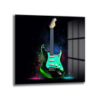 Koyu arka plan üzerinde neon yeşili ve siyah renkli, etrafında canlı pembe, mavi ve yeşil boya sıçramaları olan modern bir elektro gitarın yer aldığı cam tablo.